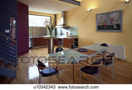Glass table and blue-seated chairs in modern yellow kitchen dining room View Large Photo Image Stock Image - Glass table and blue-seated chairs in modern yellow kitchen dining room. Fotosearch