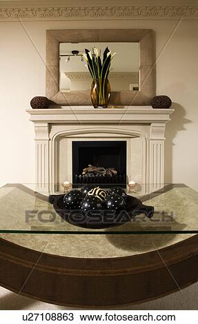 Glass topped table in front of fireplace with suede framed mirror above mantelpiece View Large Photo Image Stock Image - Glass topped table in front of fireplace with suede framed mirror above mantelpiece. Fotosearch