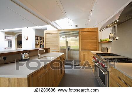Granite worktop on island unit in large modern kitchen extension with American-style fridge-freezer and range oven View Large Photo Image Stock Photograph - Granite worktop on island unit in large modern kitchen extension with American-style fridge-freezer and range oven. Fotosearch