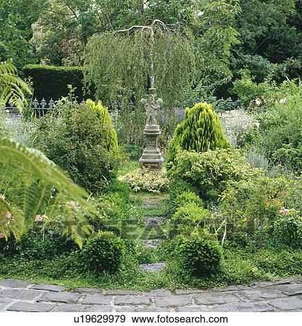 Grassed-over path to classical sculpture on plinth in green country garden View Large Photo Image Stock Photo - Grassed-over path to classical sculpture on plinth in green country garden. Fotosearch
