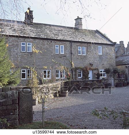 Gravel Drive And Low Stone Wall In Front Of Traditional Gravel Drive And Low Stone Wall In Front Of Traditional