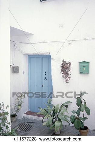 Green plants in pots in front of blue door of white Spanish village house View Large Photo Image Stock Photo - Green plants in pots in front of blue door of white Spanish village house. Fotosearch