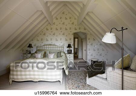 Green silk quilt on upholstered antique bed in country bedroom with green floral wallpaper and apex ceiling View Large Photo Image Picture - Green silk quilt on upholstered antique bed in country bedroom with green floral wallpaper and apex ceiling. Fotosearch