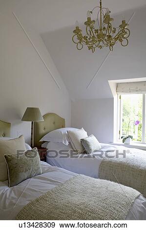 Stock Photo - Green throws and cushions on twin beds in small white country bedroom . Fotosearch