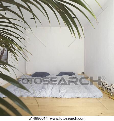 Grey duvet on futon bed on floor of economy-style bedroom View Large Photo Image Picture - Grey duvet on futon bed on floor of economy-style bedroom. Fotosearch