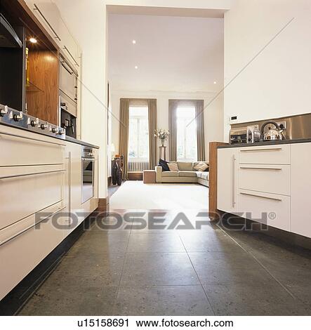 Stock Image - Grey flooring in kitchen leading into townhouse living room . Fotosearch