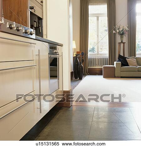 Grey flooring in kitchen leading into townhouse living room with white carpet View Large Photo Image Stock Photography - Grey flooring in kitchen leading into townhouse living room with white carpet. Fotosearch