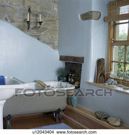 Grey rolltop bath in pastel blue cottage bathroom with exposed stone wall View Large Photo Image Picture - Grey rolltop bath in pastel blue cottage bathroom with exposed stone wall. Fotosearch