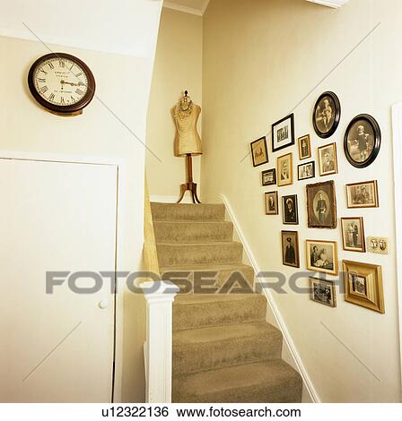 Group of family photographs on wall above staircase with beige carpet View Large Photo Image Stock Photograph - Group of family photographs on wall above staircase with beige carpet. Fotosearch