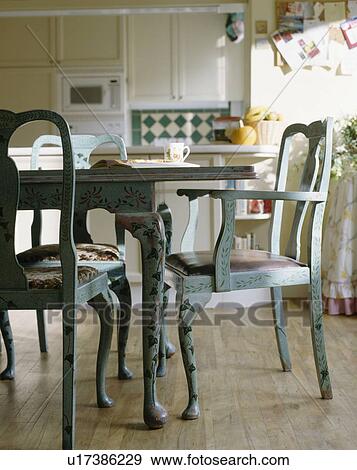 Hand-painted floral decoration on pale blue chairs and table in traditional kitchen with wooden flooring View Large Photo Image Stock Photo - Hand-painted floral decoration on pale blue chairs and table in traditional kitchen with wooden flooring. Fotosearch