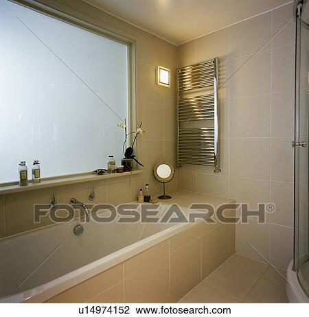 Heated Radiator Towel Rail Above Bath In Modern Beige Tiled Bathroom Stock Image U14974152 Fotosearch