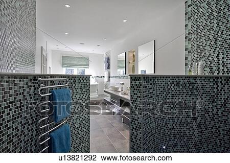 Heated towel rail on curved mosaic tiled walls in large modern bathroom View Large Photo Image Stock Image - Heated towel rail on curved mosaic tiled walls in large modern bathroom. Fotosearch