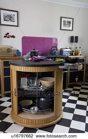 Island Unit With Black Granite Worktop And Tambour Door In Kitchen