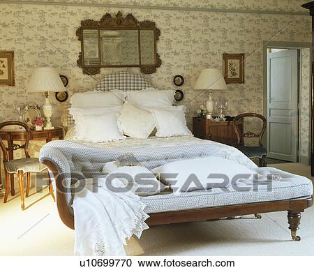 Lace-trimmed cushions and linen on pale blue chaise-longue below bed piled with white pillows in country bedroom View Large Photo Image Stock Image - Lace-trimmed cushions and linen on pale blue chaise-longue below bed piled with white pillows in country bedroom. Fotosearch
