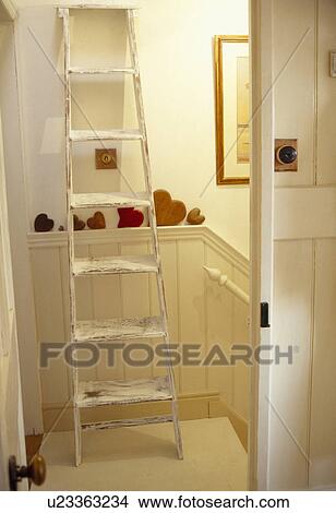 Picture - Ladder against wall on traditional cream landing. Fotosearch