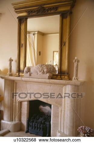 Large antique gilt mirror above fireplace with stone lion and small stone statues View Large Photo Image Stock Photo - Large antique gilt mirror above fireplace with stone lion and small stone statues. Fotosearch