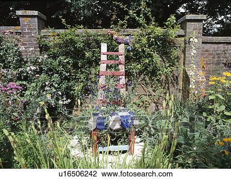 Stock Image - Large hand-made sculptural chair in walled garden. Fotosearch