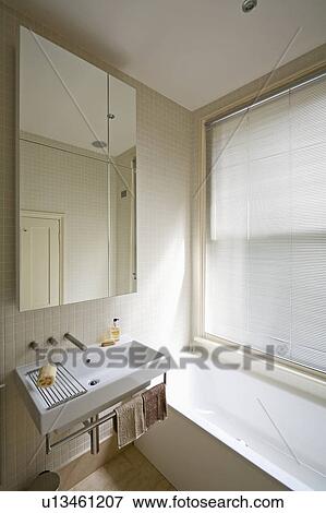 Large mirrored cabinet above rectangular white basin in modern bathroom View Large Photo Image Stock Photo - Large mirrored cabinet above rectangular white basin in modern bathroom. Fotosearch