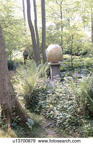 Stock Photo - Large modern ceramic pot on plinth in woodland with ferns . Fotosearch