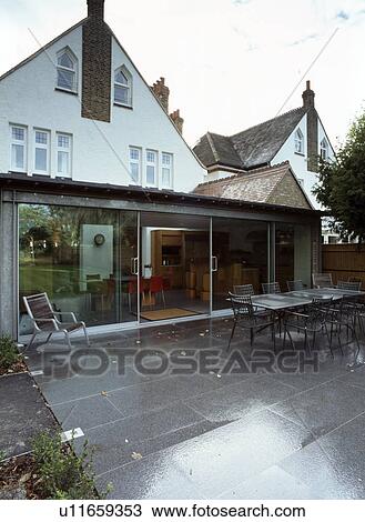 Large modern kitchen and dining room extension on traditional house with paved patio View Large Photo Image Stock Image - Large modern kitchen and dining room extension on traditional house with paved patio. Fotosearch
