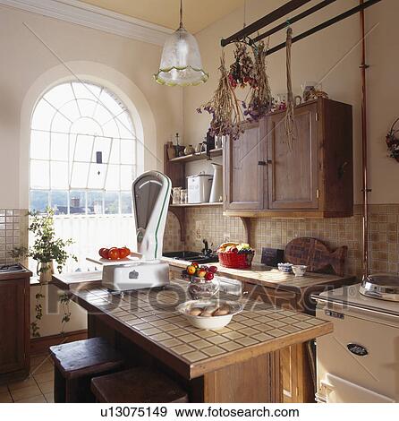 Large old scales on tiled island unit in small kitchen in converted chapel View Large Photo Image Stock Photo - Large old scales on tiled island unit in small kitchen in converted chapel. Fotosearch
