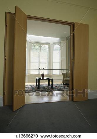 Large plain wooden double folding doors open to modern townhouse landing View Large Photo Image Stock Image - Large plain wooden double folding doors open to modern townhouse landing. Fotosearch