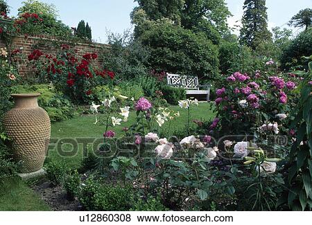 Large terracotta pithoi pot beside pink roses in scented border in large walled country garden View Large Photo Image Stock Photo - Large terracotta pithoi pot beside pink roses in scented border in large walled country garden. Fotosearch