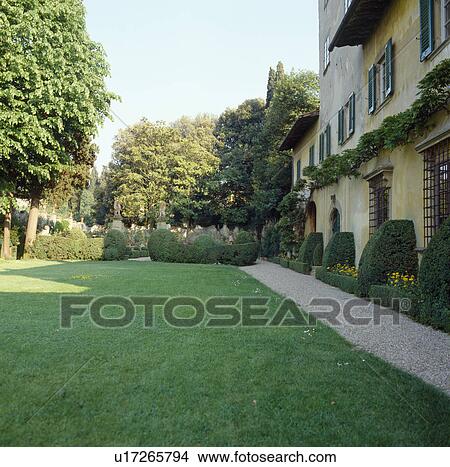 Lawn and gravel path edged with clipped shrubs in front of large Italian villa View Large Photo Image Picture - Lawn and gravel path edged with clipped shrubs in front of large Italian villa. Fotosearch