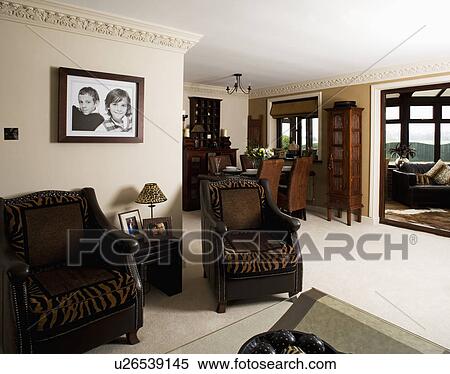 Leather armchairs with tigerprint cushions in openplan living and dining room with cream carpet View Large Photo Image Stock Photography - Leather armchairs with tigerprint cushions in openplan living and dining room with cream carpet. Fotosearch