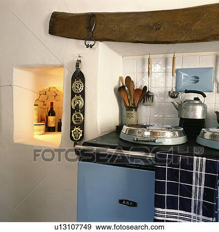 Lighted alcove and horse-brasses beside blue Aga oven in cottage kitchen View Large Photo Image Stock Photo - Lighted alcove and horse-brasses beside blue Aga oven in cottage kitchen. Fotosearch