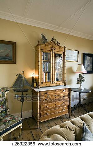 Lighted lamp on faux bamboo antique secretaire in traditional living room View Large Photo Image Stock Photograph - Lighted lamp on faux bamboo antique secretaire in traditional living room. Fotosearch