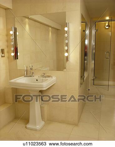 Stock Photo Of Lighted Mirror Above White Pedestal Basin In Modern Lighted Mirror Above White Pedestal Basin In Modern Bathroom