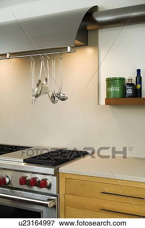 Lighting above tainless steel utensils on rack above steel range oven in modern kitchen View Large Photo Image Stock Photo - Lighting above tainless steel utensils on rack above steel range oven in modern kitchen. Fotosearch