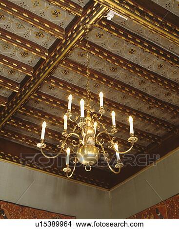 Picture - Looking up at brass chandelier and painted beamed ceiling. Fotosearch