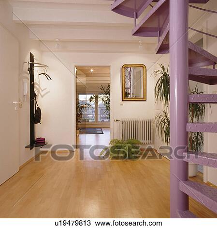 Mauve metal spiral staircase in modern white hall with wooden flooring and view of living room through open door View Large Photo Image Stock Image - Mauve metal spiral staircase in modern white hall with wooden flooring and view of living room through open door. Fotosearch