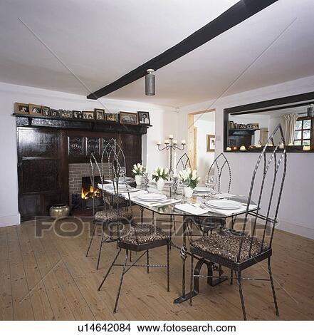Metal Gothic-style chairs and table with white crockery in white country dining room with wooden flooring View Large Photo Image Picture - Metal Gothic-style chairs and table with white crockery in white country dining room with wooden flooring. Fotosearch