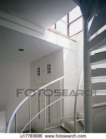 Stock Photograph - Metal spiral staircase in modern white hall. Fotosearch