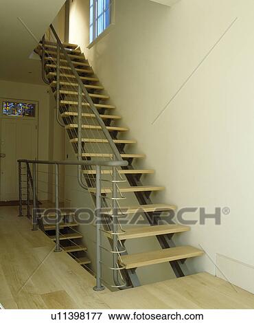 Stock Photo - Metal staircase with open wooden treads on modern landing. Fotosearch