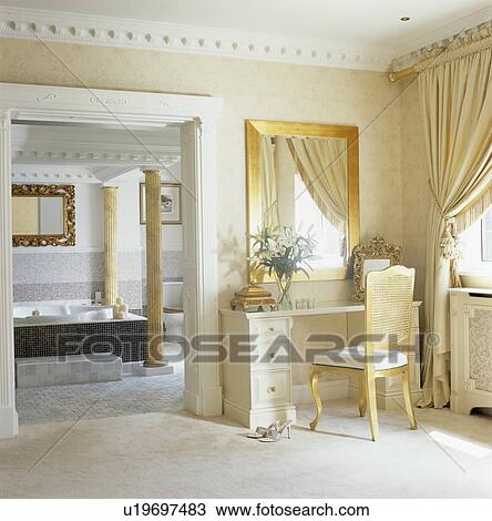 Mirror above dressing-table and chair beside door to opulent ensuite bathroom View Large Photo Image Stock Image - Mirror above dressing-table and chair beside door to opulent ensuite bathroom. Fotosearch