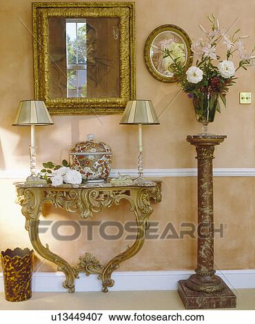 Stock Photo - Mirror and ornate console table in traditional cream hall. Fotosearch