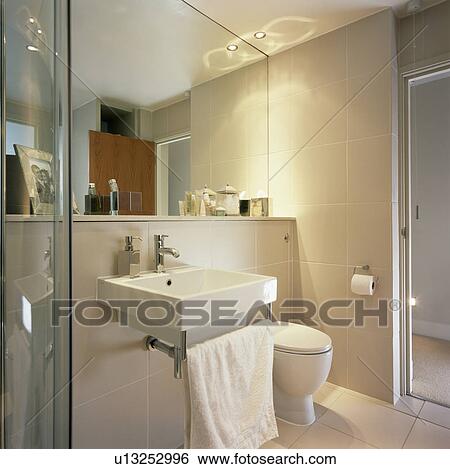 Stock Photograph - Mirrored wall above rectangular basin in modern bathroom. Fotosearch