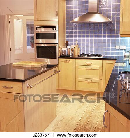 Modern kitchen with granite-topped island unit and reclaimed floorboards View Large Photo Image Stock Image - Modern kitchen with granite-topped island unit and reclaimed floorboards. Fotosearch