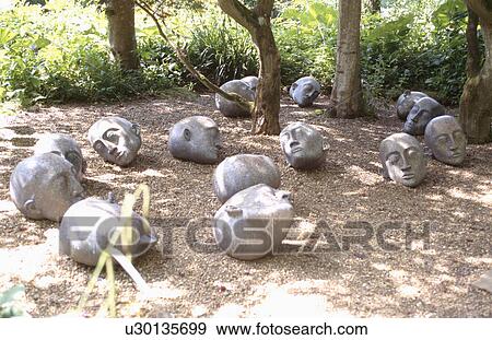 Modern sculptural heads on the ground below trees View Large Photo Image Stock Photo - Modern sculptural heads on the ground below trees. Fotosearch