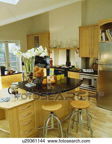 Modern townhouse kitchen with stools at breakfast bar with black granite worktop View Large Photo Image Picture - Modern townhouse kitchen with stools at breakfast bar with black granite worktop. Fotosearch