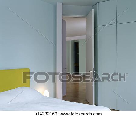 Modern turquoise bedroom with fitted wardrobe beside open door to landing View Large Photo Image Stock Photo - Modern turquoise bedroom with fitted wardrobe beside open door to landing. Fotosearch