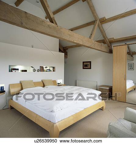 Modern white attic bedroom with beamed apex ceiling View Large Photo Image Stock Image - Modern white attic bedroom with beamed apex ceiling. Fotosearch