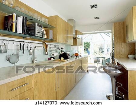 Modern white kitchen with pale wood units and glass splashbacks View Large Photo Image Stock Image - Modern white kitchen with pale wood units and glass splashbacks. Fotosearch