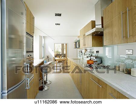 Modern white kitchen with pale wood units View Large Photo Image Stock Photograph - Modern white kitchen with pale wood units . Fotosearch