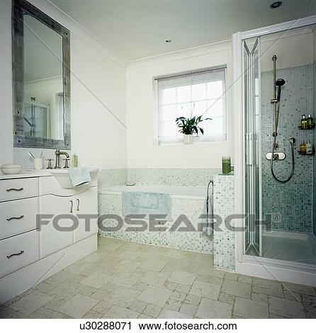 Mosaic tiled bath in modern white bathroom with fitted vanity unit View Large Photo Image Stock Image - Mosaic tiled bath in modern white bathroom with fitted vanity unit. Fotosearch