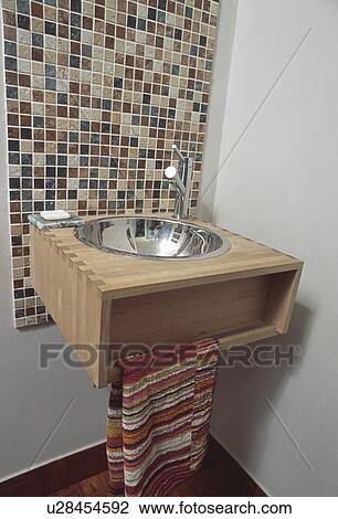 Mosaic wall tiles above Philippe Starck stainless steel tap and basin in wooden vanity unit View Large Photo Image Stock Image - Mosaic wall tiles above Philippe Starck stainless steel tap and basin in wooden vanity unit. Fotosearch